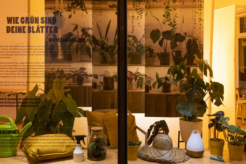 Illuminated window with houseplants and canvases printed with plants.