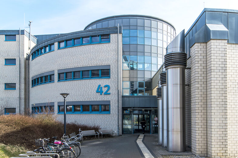 Photo of the building at Emil-Figge-Strasse 42 and its entrance with a walkway and guidance system for the blind.