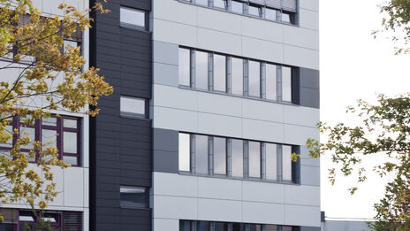 Photo of part of the building Emil-Figge-Straße 44 of the Fachhochschule Dortmund with a meadow in front of it.