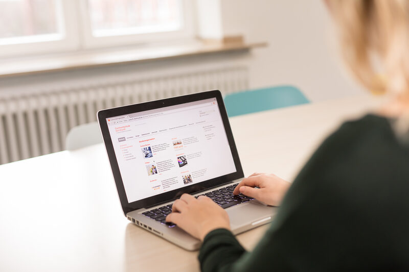 Photo of a student visits the Fachhochschule Dortmund website on her laptop. __ A student visits the Dortmund University of Applied Sciences website on her laptop.