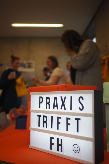 Leuchtbox mit dem Schriftzug Praxis trifft FH