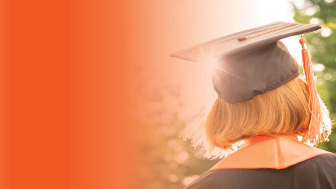 Doctoral students in the sunlight with doctoral hats