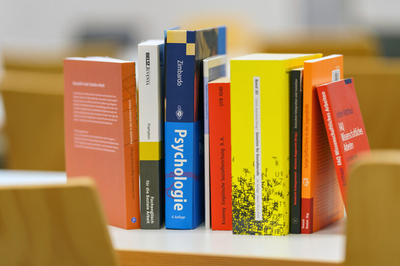 Photo of a still life consisting of books of different sizes leaning against each other on a table.