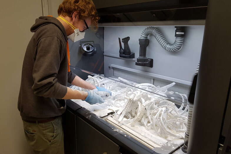 Photo of an employee processing 3D prints.