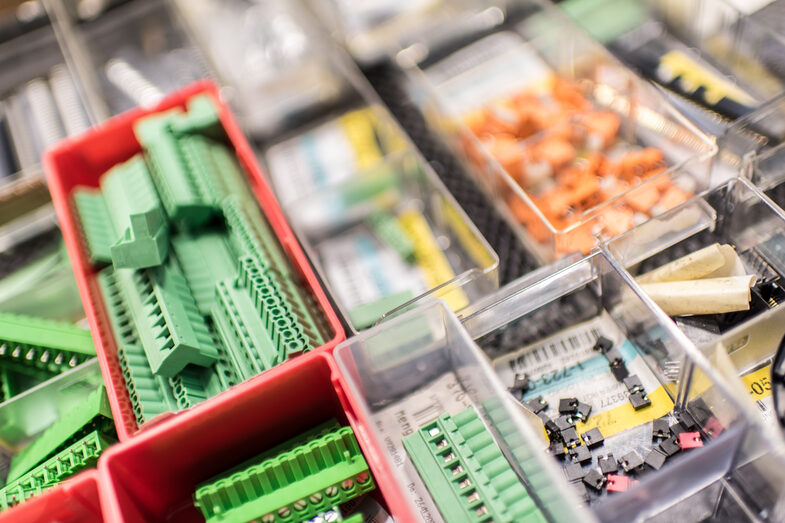 Close-up of several boxes with electronic accessories and small parts in the laboratory for electronics and automation.