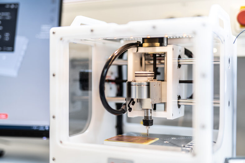 Photo of a milling machine milling something onto a circuit board.